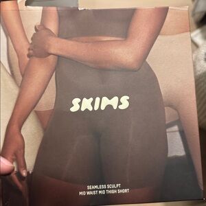 SKIMS Seamless Sculpt Mid Waist Shorts in Black and Tan